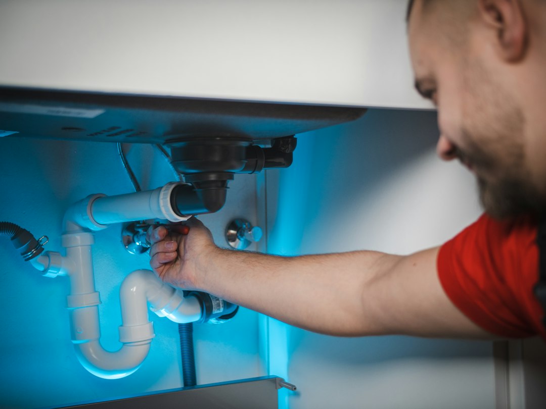 Professional plumber repairing pipework inside a home